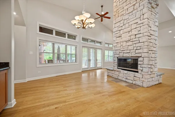 a view of an empty room with a fireplace and a chandelier