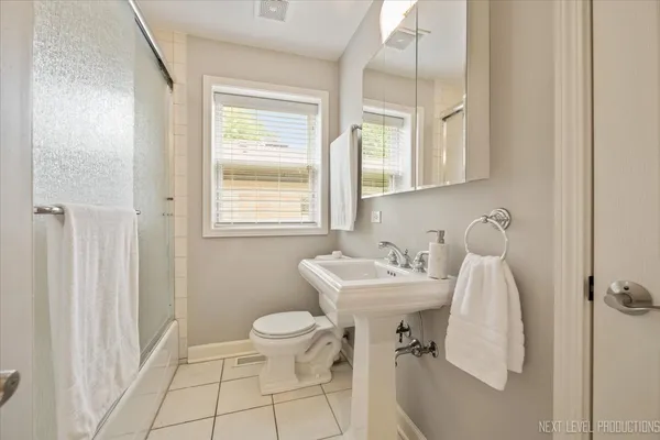 a bathroom with a sink toilet and a mirror