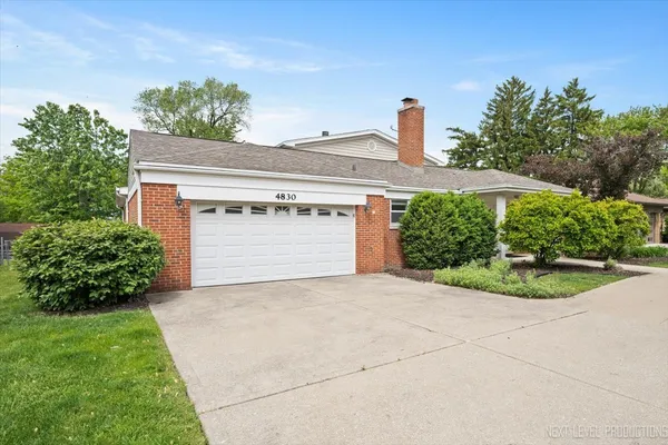 a front view of a house with a yard and a garage