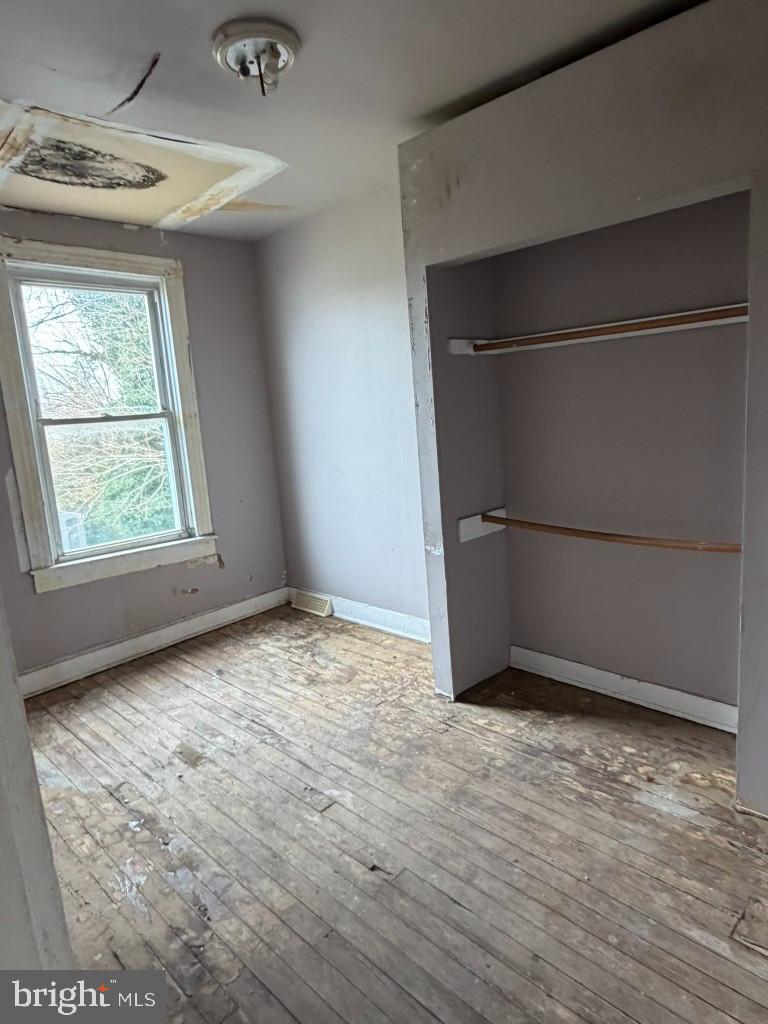 1827 North Milton Avenue Baltimore, MD 21213 - Photo 26 of 49 an empty room with wooden floor and windows