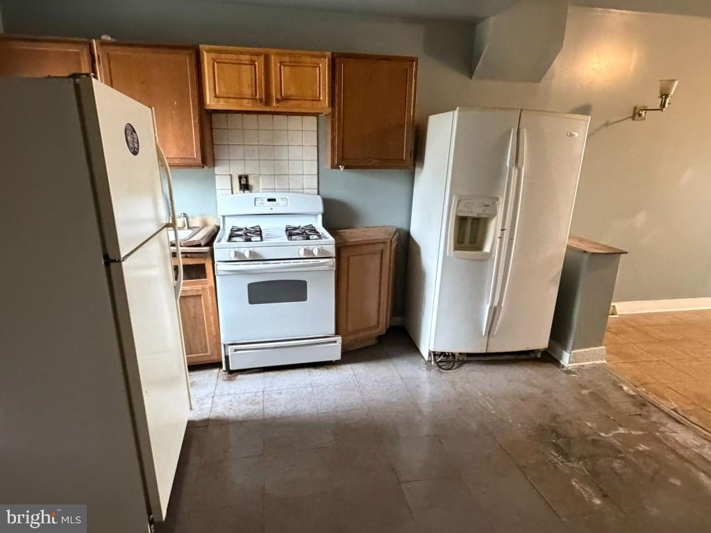 1827 North Milton Avenue Baltimore, MD 21213 - Photo 9 of 49 a white refrigerator freezer and a stove sitting inside of a kitchen