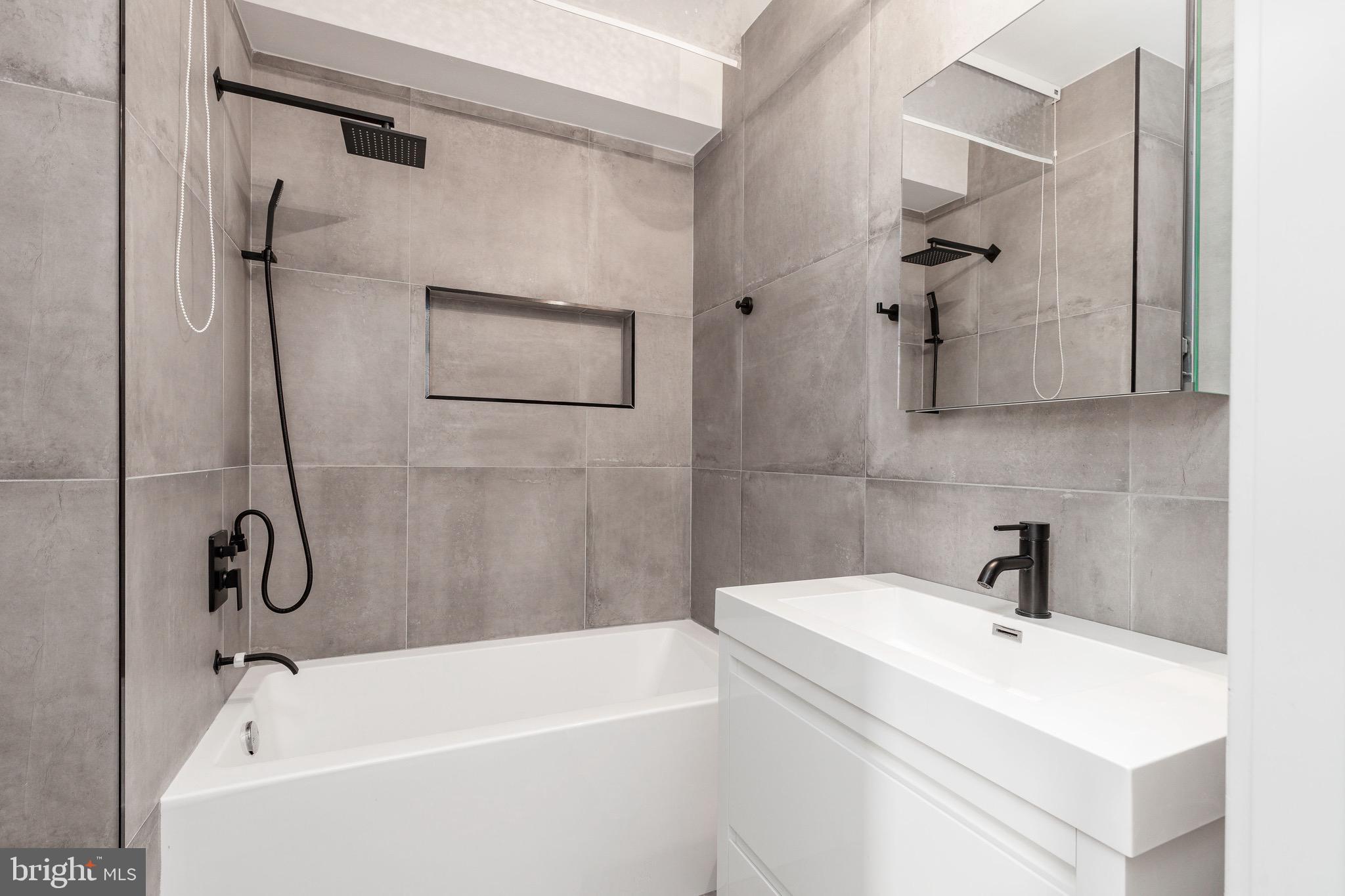 1733 Carpenter Street, Unit D Philadelphia, PA 19146 - Photo 26 of 37 a white bath tub sitting next to a white sink and a shower