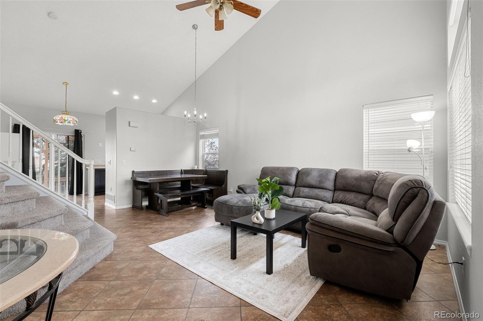 3828 South Rome Way Aurora, CO 80018 - Photo 2 of 19 a living room with furniture and a dining table with kitchen view
