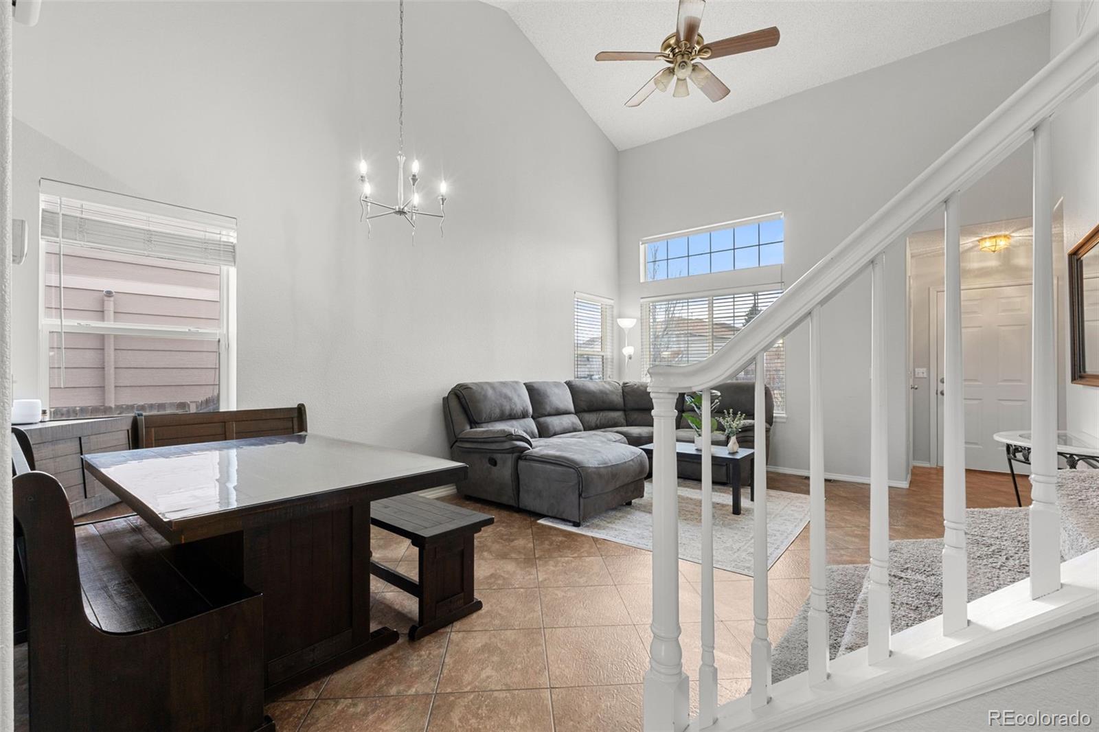 3828 South Rome Way Aurora, CO 80018 - Photo 3 of 19 a living room with furniture a chandelier and a window