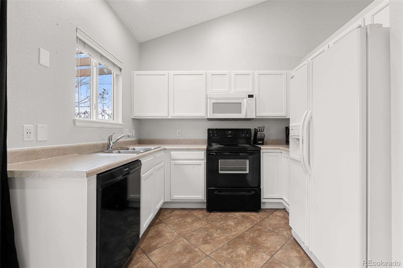 3828 South Rome Way Aurora, CO 80018 - Photo 4 of 19 a kitchen with stainless steel appliances granite countertop a stove and a refrigerator