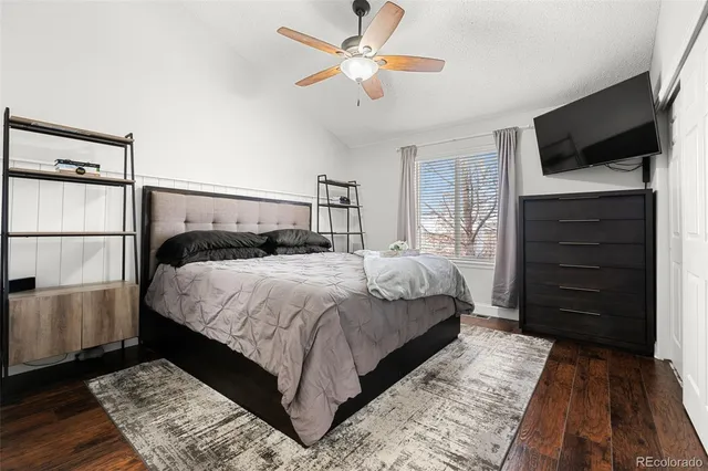 a bedroom with a bed and a flat tv screen on dresser
