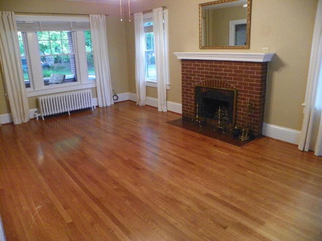 2107 Carter Road Southwest Roanoke, VA 24015 - Photo 8 of 18 an empty room with wooden floor fireplace and windows
