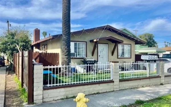 a view of a house with a small yard and wooden fence