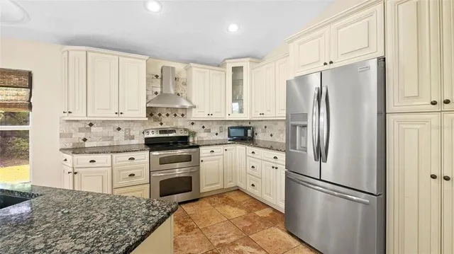 a kitchen with stainless steel appliances granite countertop a refrigerator sink and cabinets