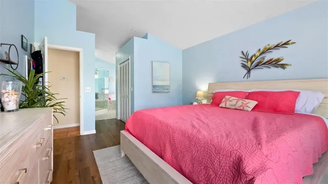 a bedroom with a bed and a potted plant on dresser