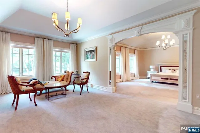 a spacious bedroom with furniture and a chandelier
