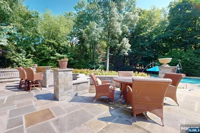 a view of a swimming pool with lawn chairs under an umbrella