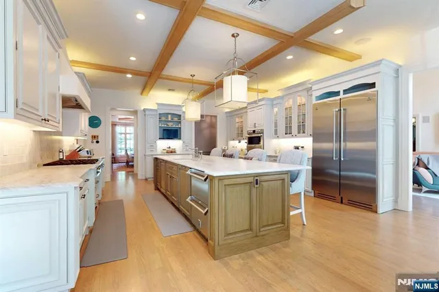 a kitchen with stainless steel appliances granite countertop a lot of cabinets a sink and wooden floor