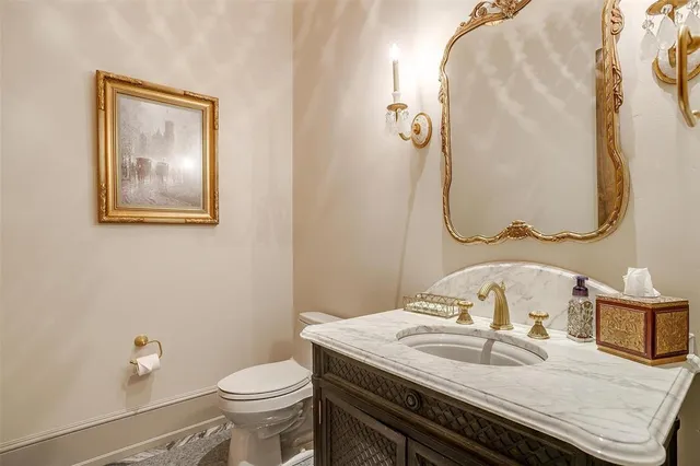 a bathroom with a granite countertop toilet sink and mirror