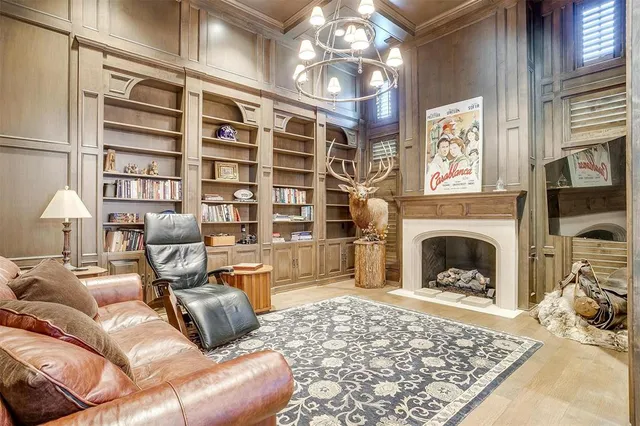 a living room with furniture a fireplace and a chandelier