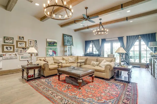 a living room with furniture a chandelier and a large window