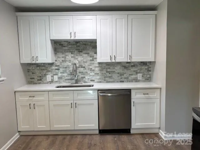 a kitchen with white cabinets sink and dishwasher