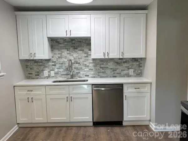 a kitchen with white cabinets sink and dishwasher