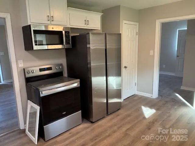 a kitchen with granite countertop a refrigerator and a stove top oven