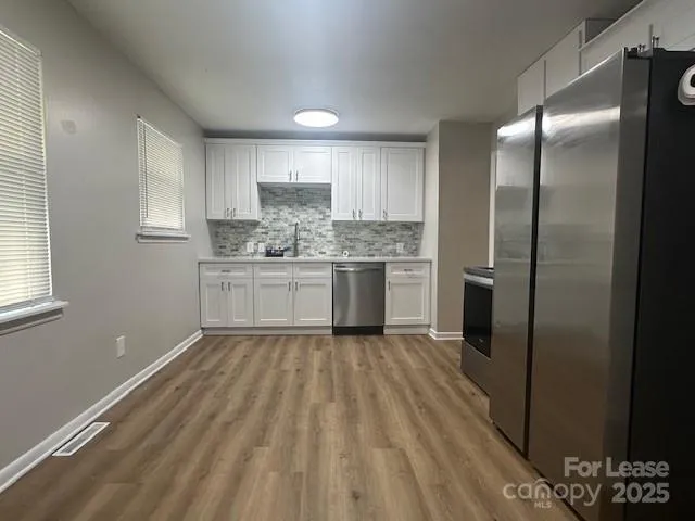 a kitchen with stainless steel appliances granite countertop a refrigerator and a sink