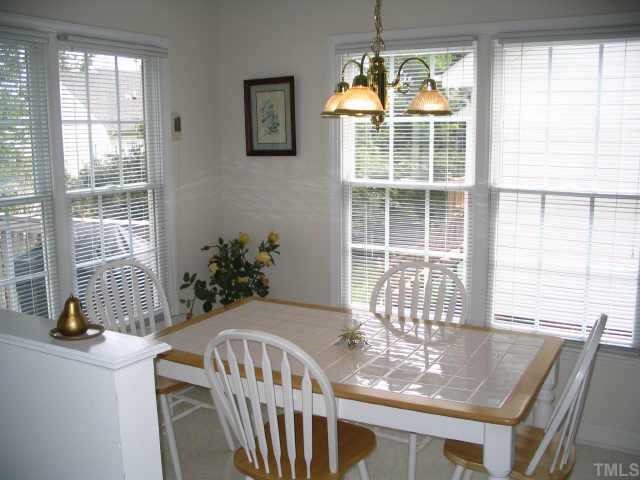 8633 Harps Mill Road Raleigh, NC 27615 - Photo 6 of 10 a dining room with furniture a chandelier and wooden floor
