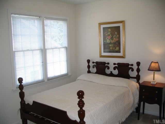 8633 Harps Mill Road Raleigh, NC 27615 - Photo 8 of 10 a bedroom with a bed and a window