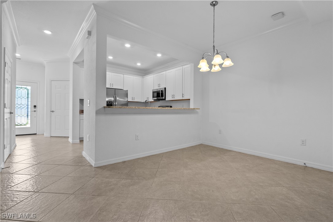 12568 Westhaven Way Fort Myers, FL 33913 - Photo 9 of 26 a view of a kitchen with a refrigerator a sink a cabinet and a chandelier