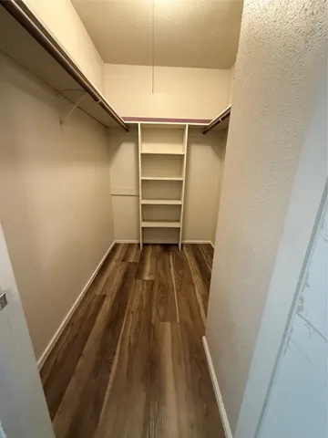 a view of walk in closet with clothes