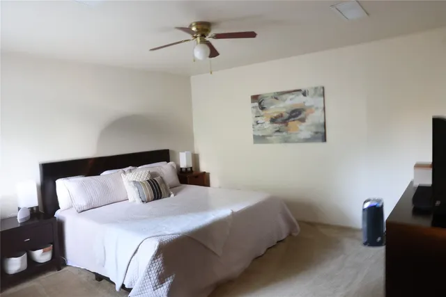 a bedroom with a bed and a painting on the wall