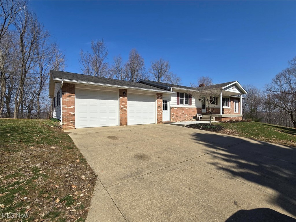 6376 Nichols Road Malta, OH 43758 - Photo 1 of 23 Ranch-style house with a front lawn, a garage, brick siding, and driveway