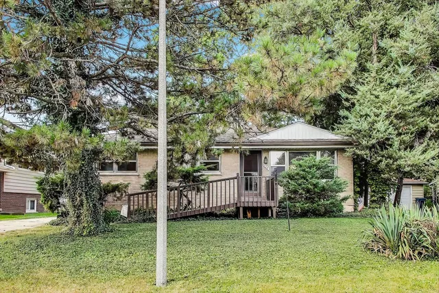 a view of a house with backyard and a tree