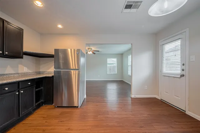 a kitchen with granite countertop a refrigerator and a stove top oven