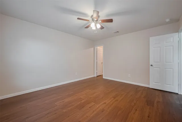 a view of an empty room with wooden floor