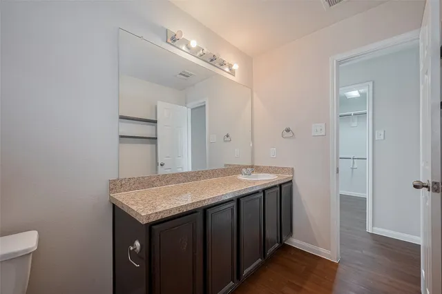 a bathroom with a granite countertop sink and a mirror