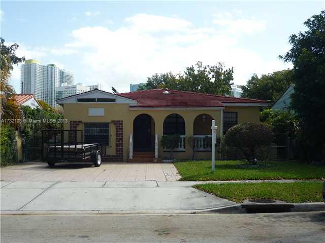 a view of a house with a yard and potted plants
