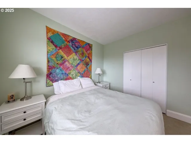 a bed room with a bed and a painting on the wall