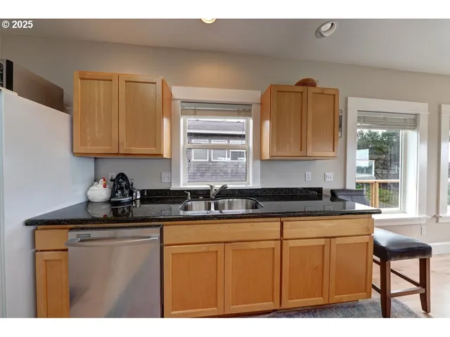 a kitchen with granite countertop a sink stove and cabinets