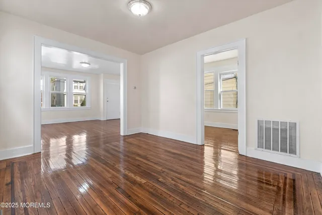 a view of an empty room and wooden floor