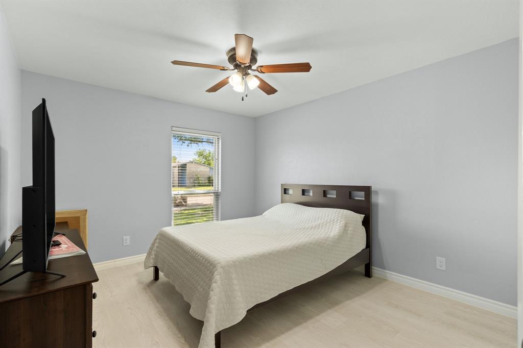 2113 Victoria Road Carrollton, TX 75007 - Photo 14 of 19 a bedroom with a bed and a flat tv screen on a dresser