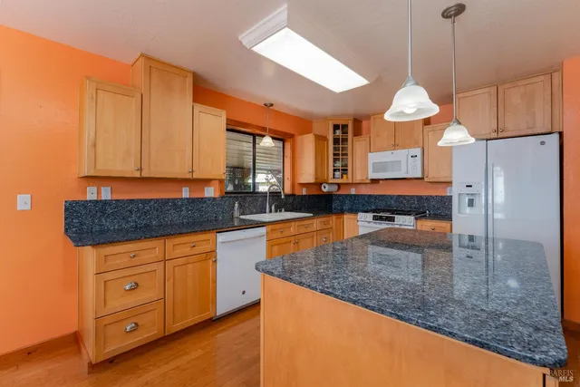 a kitchen with stainless steel appliances granite countertop a sink a stove and a refrigerator