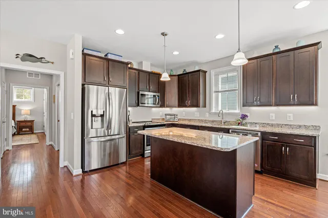 a kitchen with sink stove and wooden floor