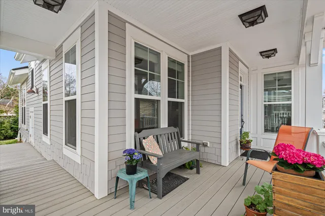 a living room with furniture kitchen view and a wooden floor