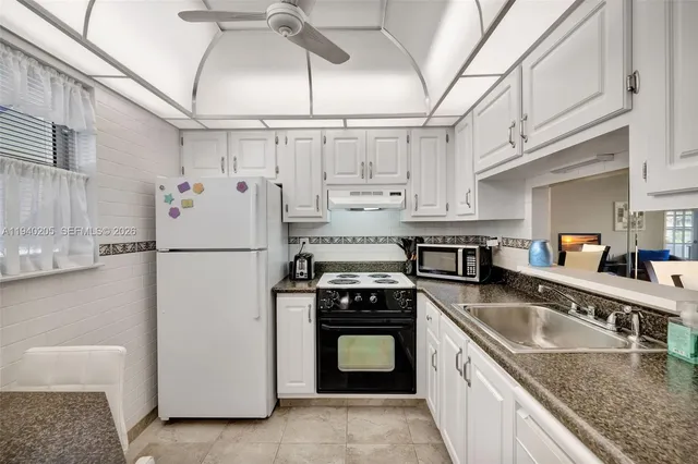 a kitchen with white cabinets appliances and sink