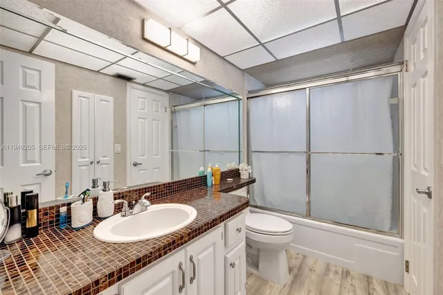 a bathroom with a granite countertop sink mirror vanity and toilet