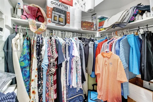 a view of walk in closet with clothes and shoes