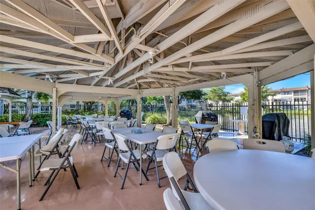 a view of a patio with table and chairs and a barbeque