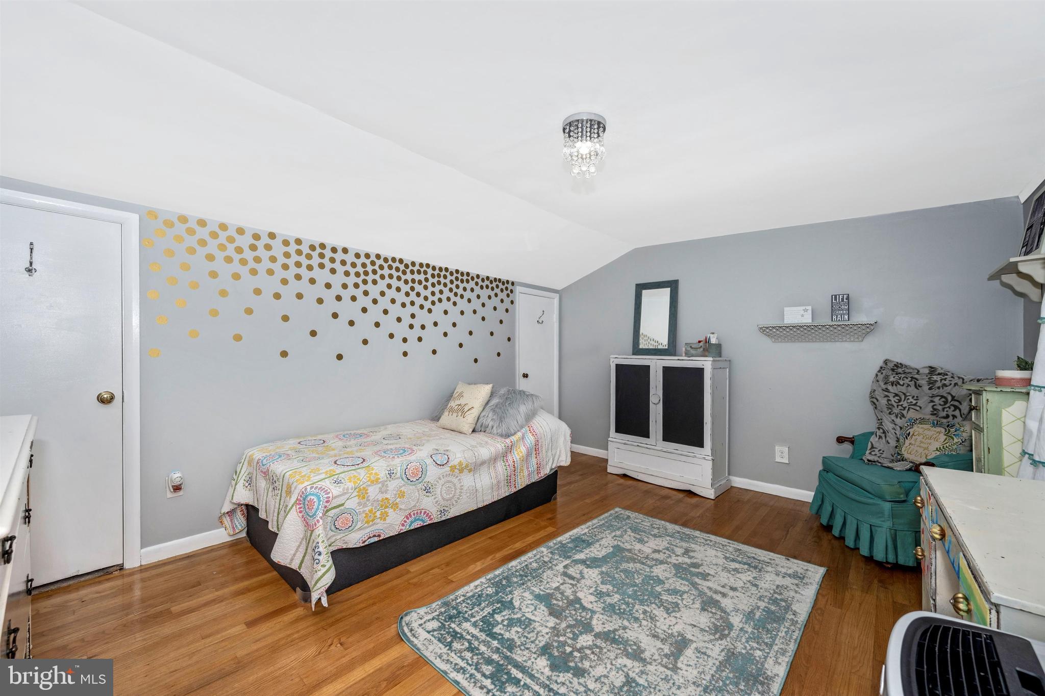 4304 Ridge Avenue Baltimore, MD 21227 - Photo 22 of 50 a bedroom with a bed and wooden floor