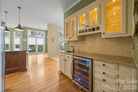 a kitchen with stainless steel appliances granite countertop a stove a sink and a refrigerator with wooden floor