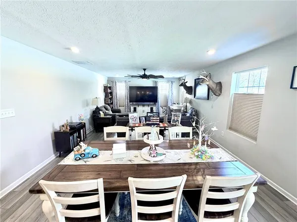 a view of empty room with wooden floor and windows