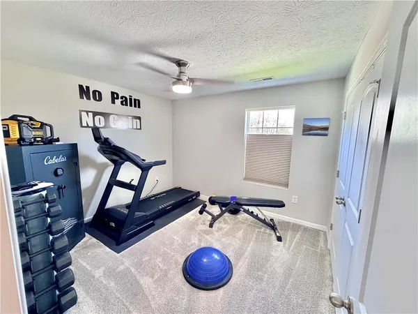 a bedroom with bed a flat tv screen and a dresser